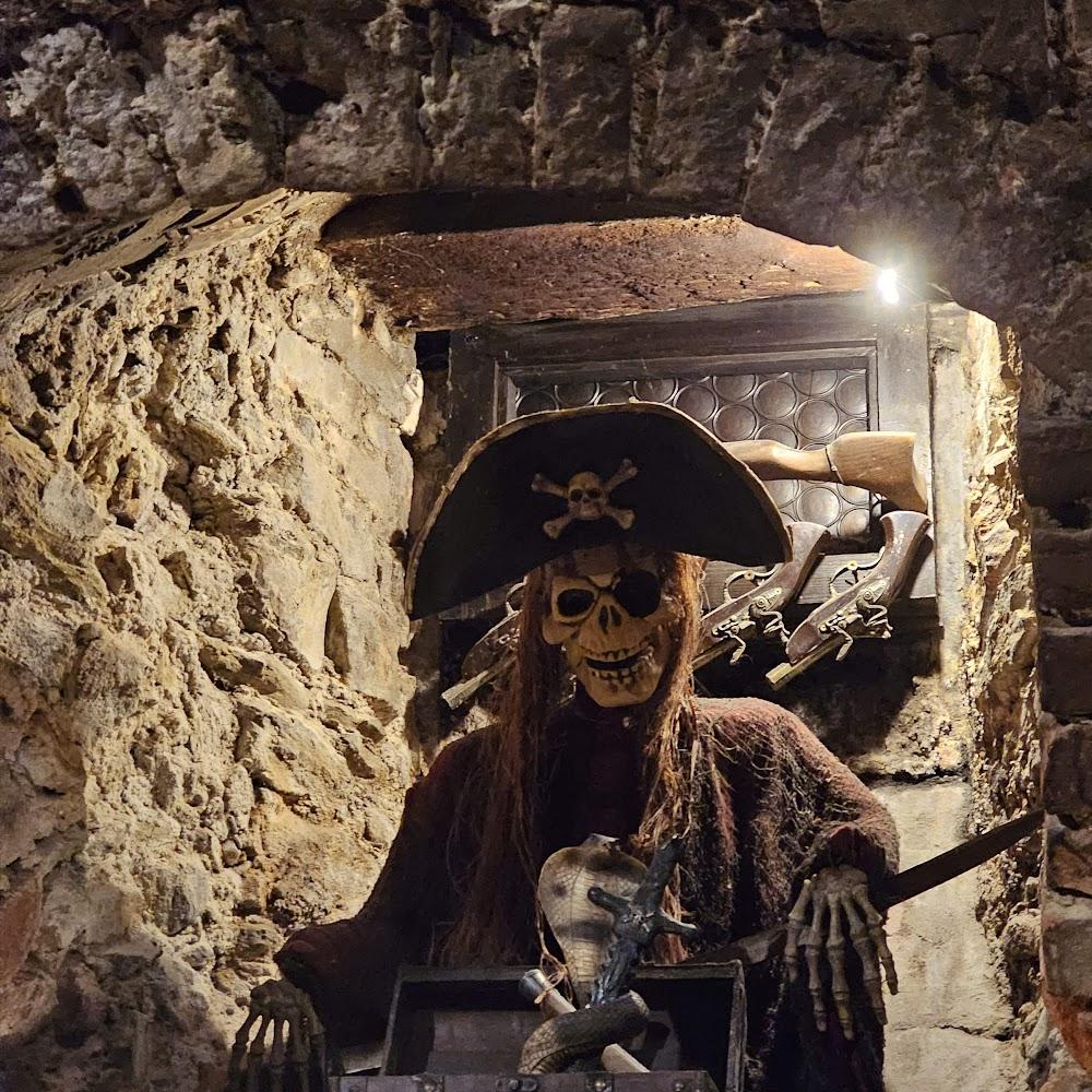 A pirate skeleton holding a sword in a stone room.